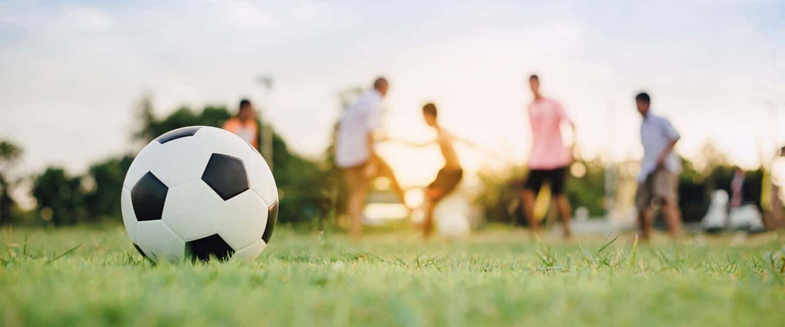 Kids playing soccer on a field during sunset at Lower Island Soccer.